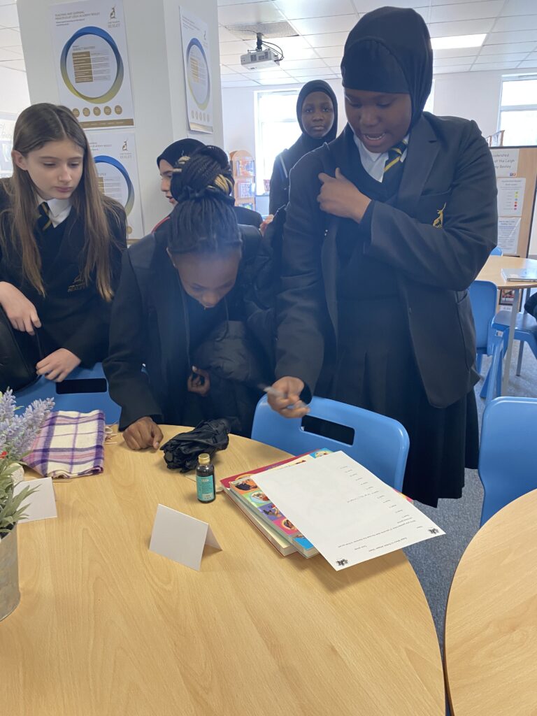 Students stood around a table participating in an activity