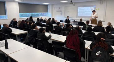 A teacher presents to a classroom of uniformed students.