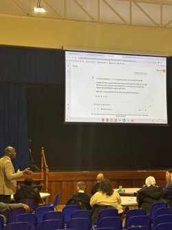 A teacher presents to a small group in an auditorium.