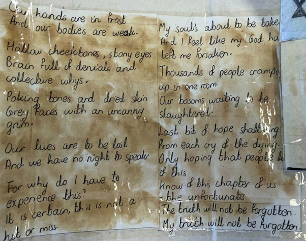 A close-up of handwritten poetry on tea-stained paper, with somber verses reflecting on the experiences of the Holocaust.