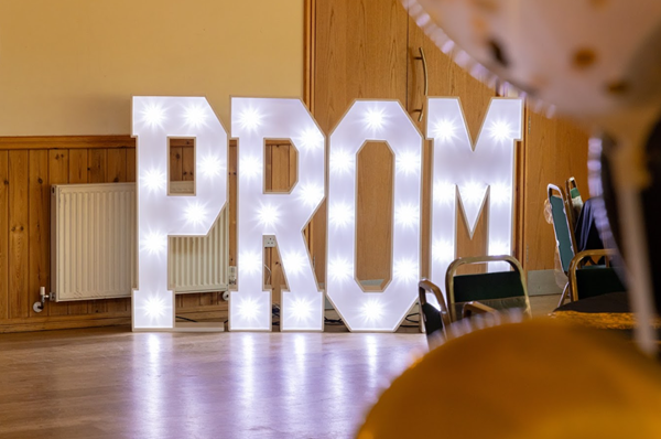 The word Prom lit up as a large sign on a floor
